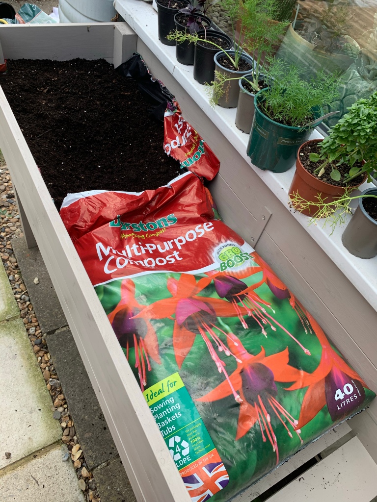 Lining herb planter with compost bags